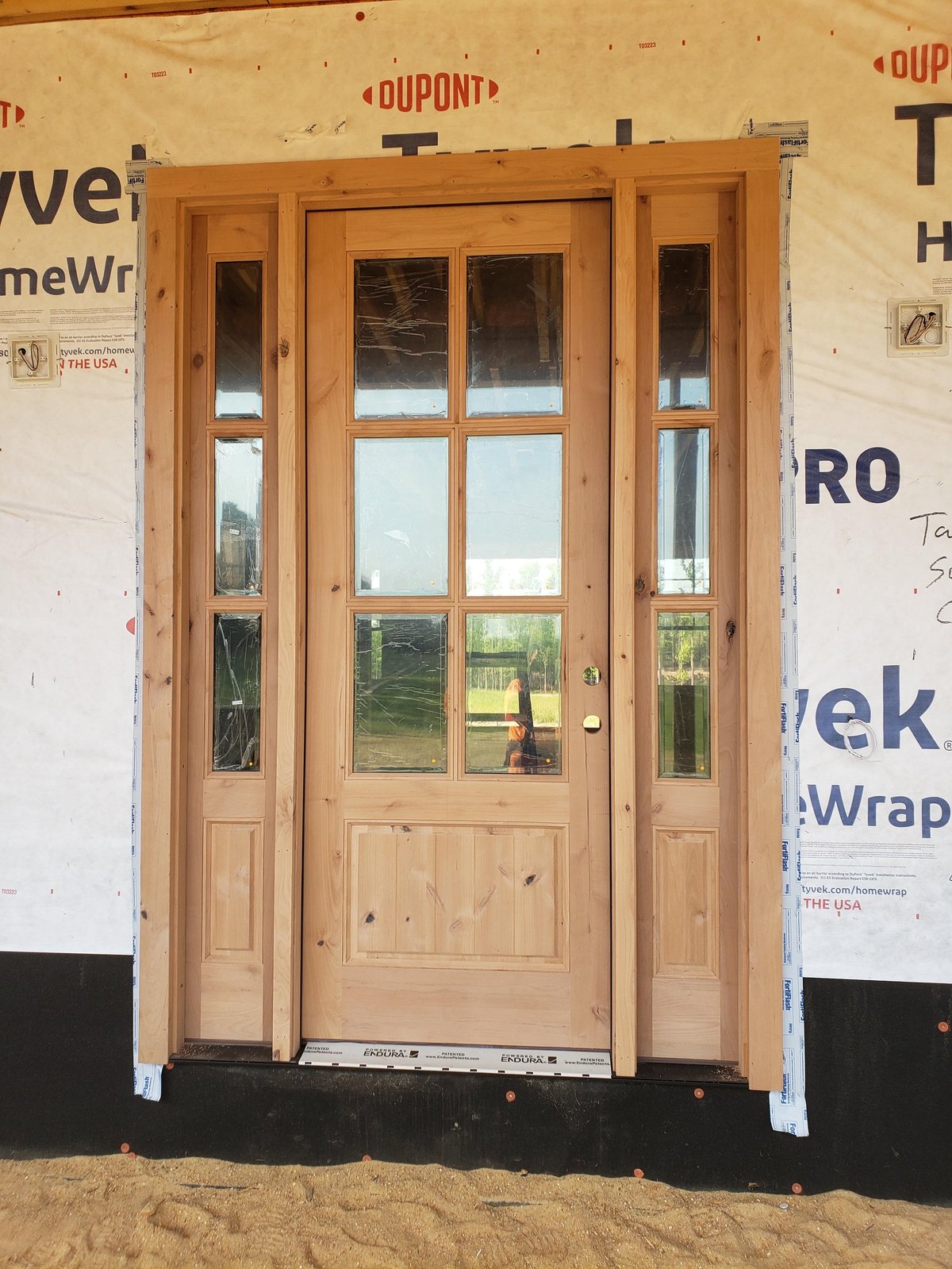 Wooden front door with glass panels and sidelights installed